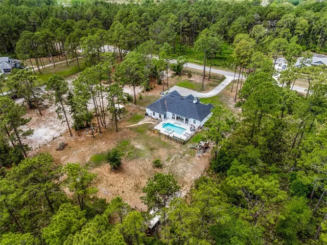 a view of a house with a backyard and a park