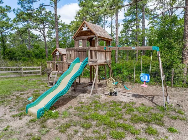 a white house with a big yard and large tree