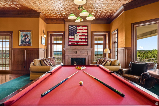 5615 East Eight Mile Gap Road Kanab, UT 84741 - Photo 34 of 81 Recreation room featuring a wainscoted wall, crown molding, a fireplace, an ornate ceiling, and wooden walls