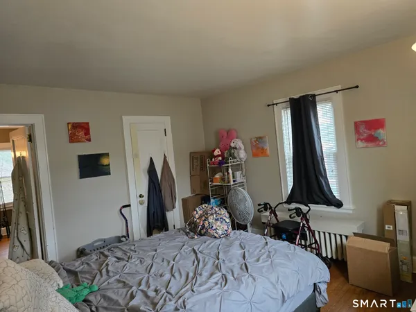 a bedroom with bed a mirror and desk