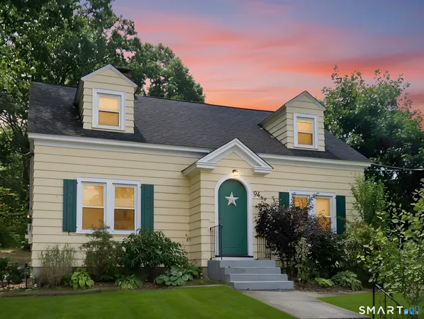 a front view of a house with a yard and trees