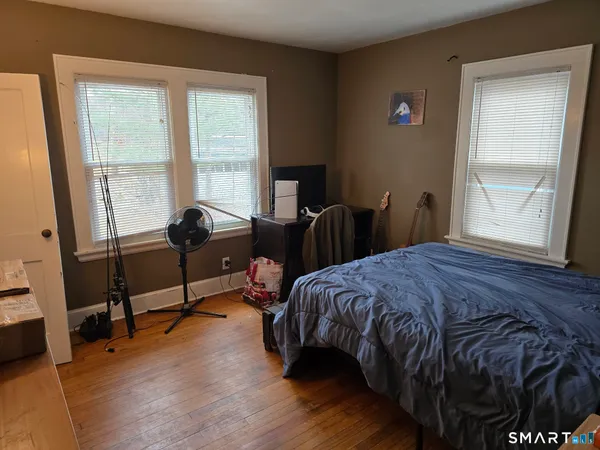 a bedroom with a bed a desk and a window
