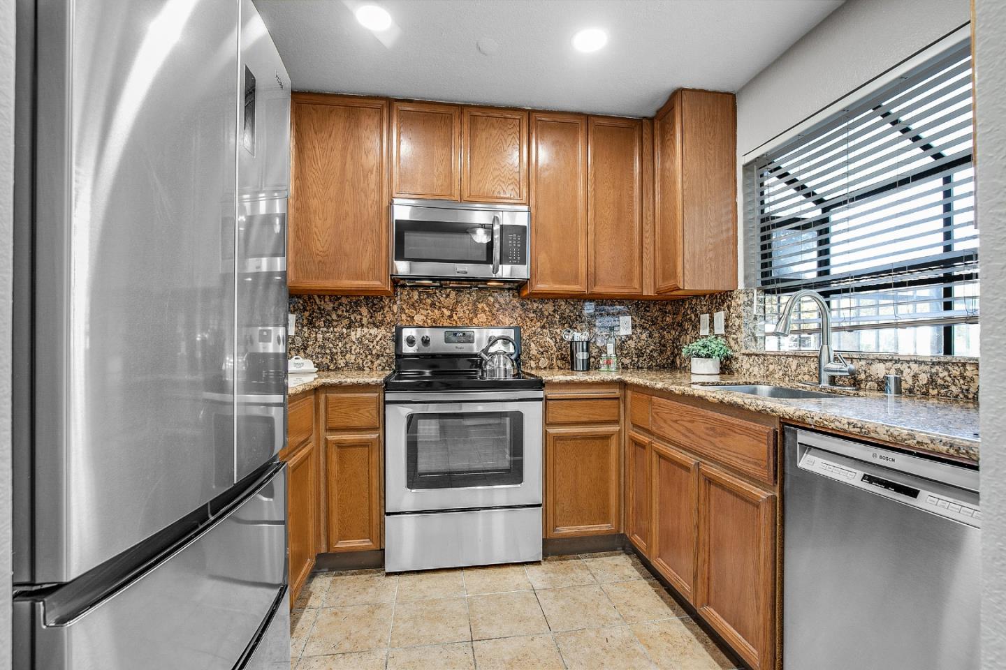 36913 Newark Boulevard, Unit A Newark, CA 94560 - Photo 4 of 20 a kitchen with stainless steel appliances granite countertop wooden cabinets a stove top oven a sink and dishwasher