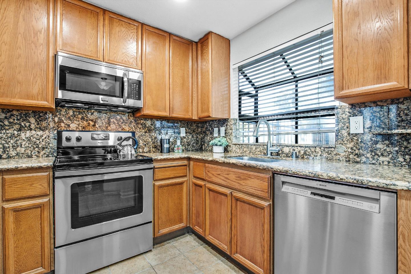 36913 Newark Boulevard, Unit A Newark, CA 94560 - Photo 5 of 20 a kitchen with stainless steel appliances granite countertop a stove microwave and sink