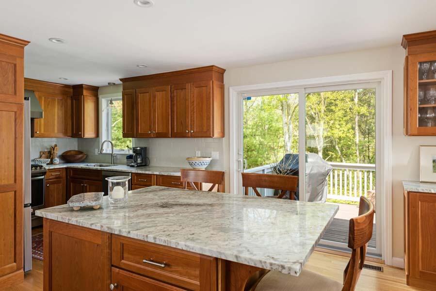 6 Wading Place Road Mashpee, MA 02649 - Photo 9 of 35 a kitchen with a sink a counter top space and living room filled with furniture