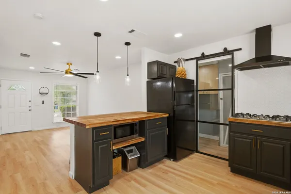 a kitchen with stainless steel appliances granite countertop a refrigerator a stove and a wooden floors