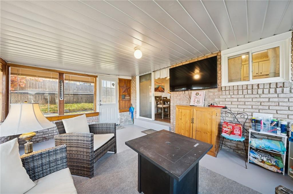588 Carmelott Street Irwin, PA 15642 - Photo 11 of 33 a living room with furniture a flat screen tv and a floor to ceiling window