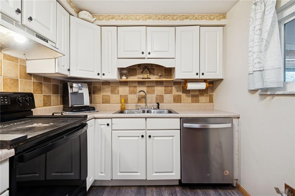 588 Carmelott Street Irwin, PA 15642 - Photo 7 of 33 a kitchen with stainless steel appliances granite countertop a stove and white cabinets