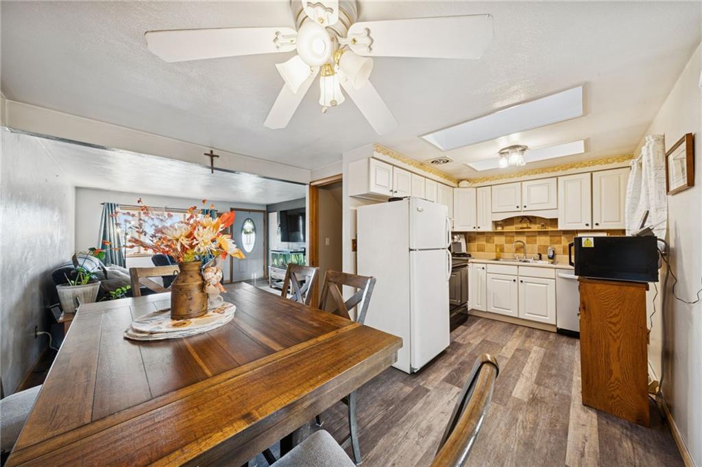 588 Carmelott Street Irwin, PA 15642 - Photo 8 of 33 a kitchen with a table chairs refrigerator and cabinets