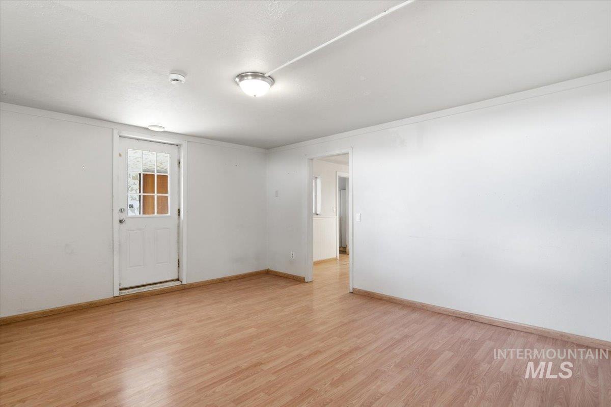 3929-3927 Homestead Road Homedale, ID 83628 - Photo 35 of 45 Wood-finish flooring with white walls, a multi-pane glass door, and a flush mount ceiling light