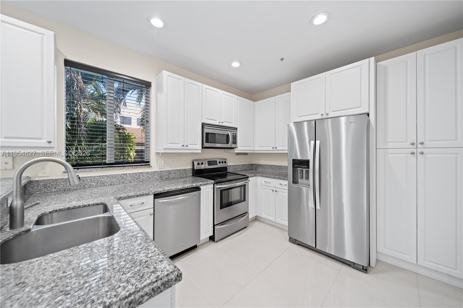2951 Virginia Street, Unit 2953 Miami, FL 33133 - Photo 13 of 18 a kitchen with stainless steel appliances granite countertop a refrigerator a sink a stove a microwave and island