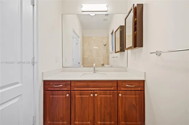 a bathroom with a sink vanity mirror and toilet
