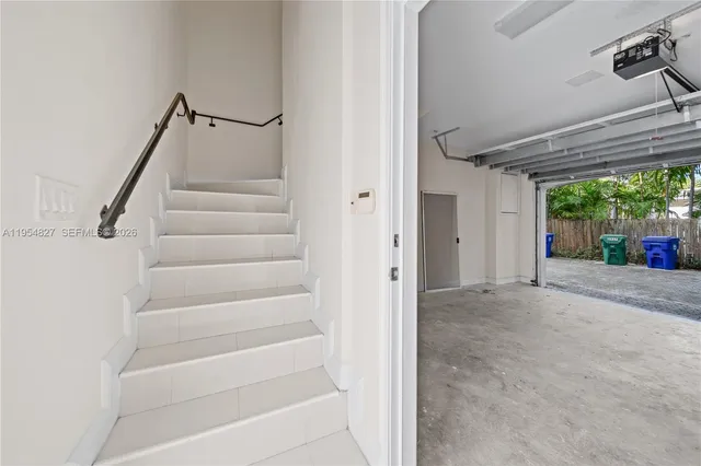 a view of an empty room with stairs and a window