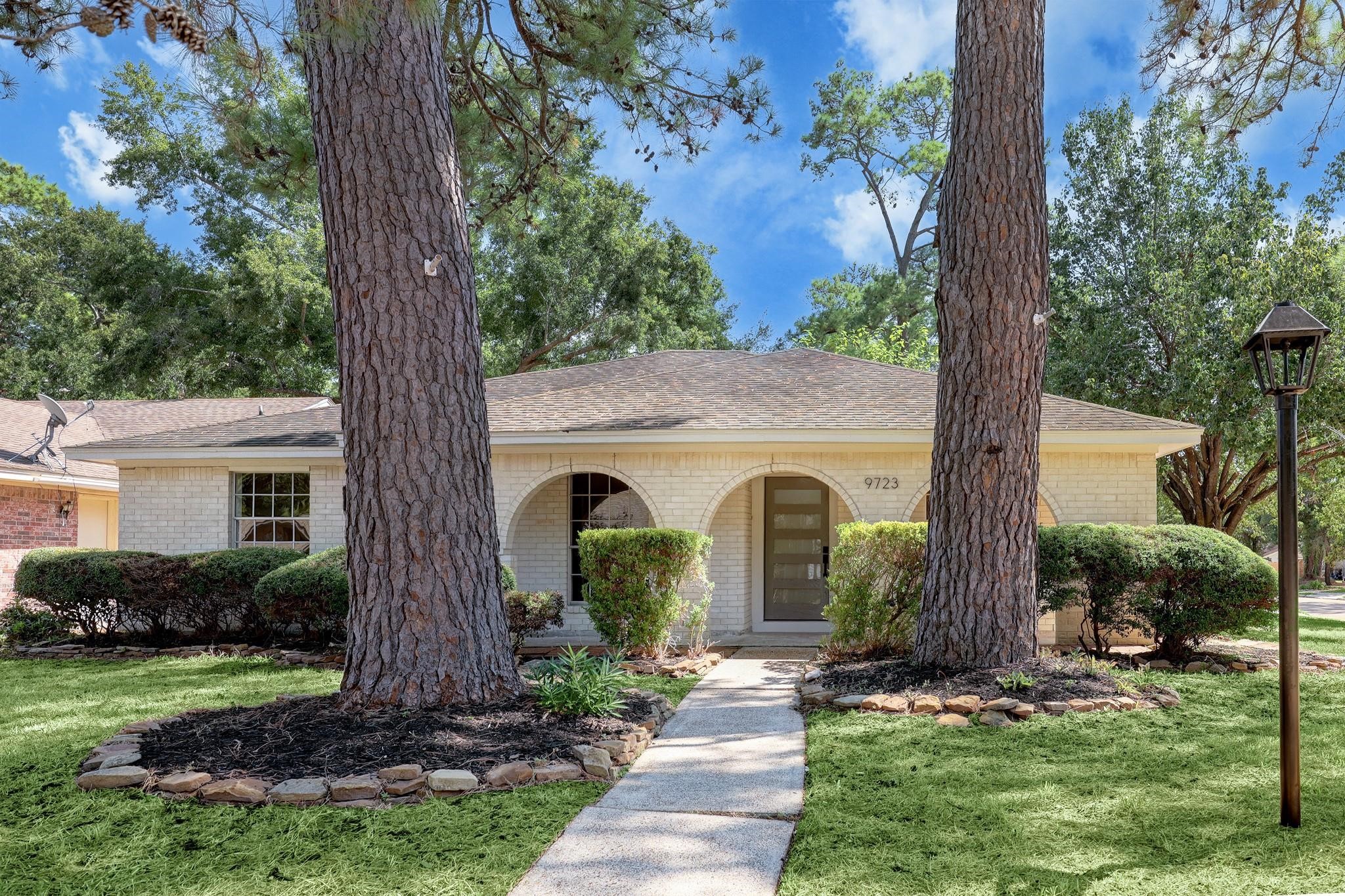 9723 Galston Lane Spring, TX 77379 - Photo 1 of 24 A lasting first impression—this corner-lot home showcases a wide covered front porch framed by graceful brick archways. The expansive front yard is shaded by mature trees.