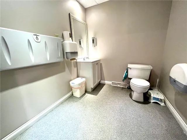 a bathroom with a toilet sink and a mirror