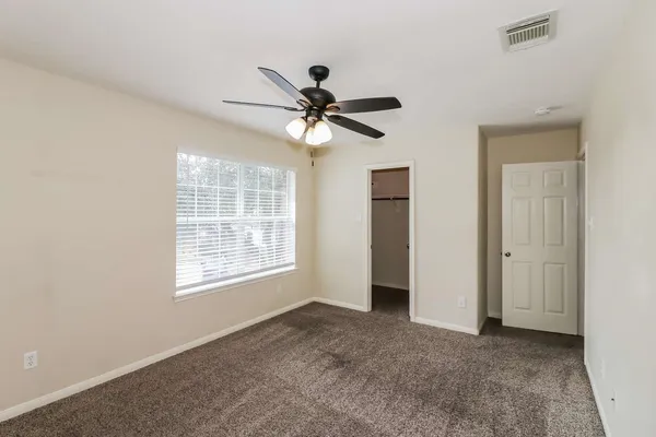 an empty room with a window and a ceiling fan