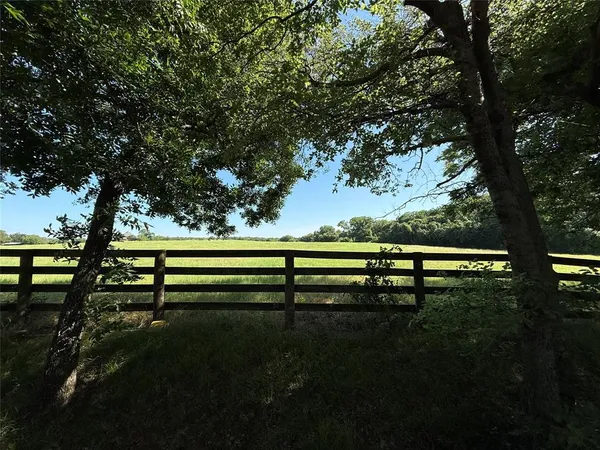 a view of park bench sitting next to a yard
