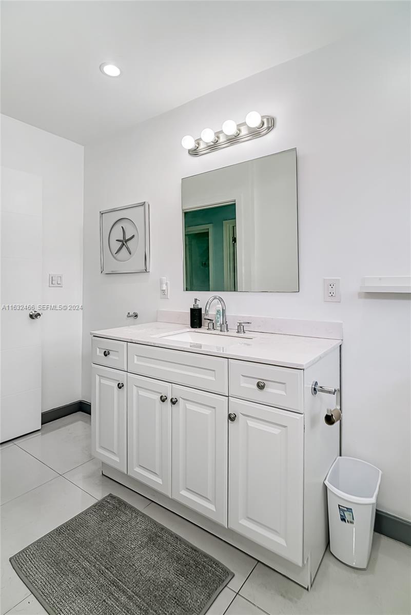216 Southwest 6th Street Hallandale Beach, FL 33009 - Photo 18 of 70 a bathroom with a double vanity sink a toilet and a mirror