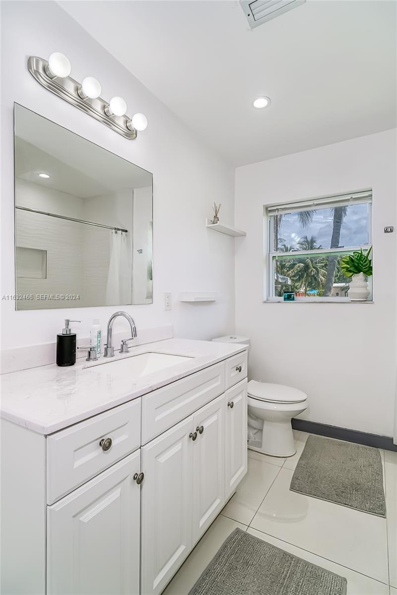 216 Southwest 6th Street Hallandale Beach, FL 33009 - Photo 19 of 70 a bathroom with a sink a toilet and a mirror