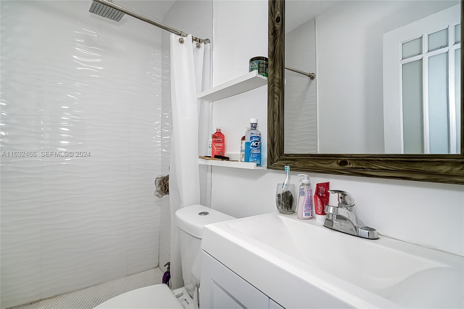 216 Southwest 6th Street Hallandale Beach, FL 33009 - Photo 26 of 70 a bathroom with a sink vanity mirror and toilet