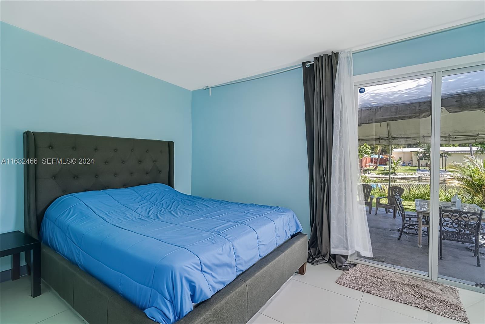 216 Southwest 6th Street Hallandale Beach, FL 33009 - Photo 29 of 70 a bedroom with a bed and glass door