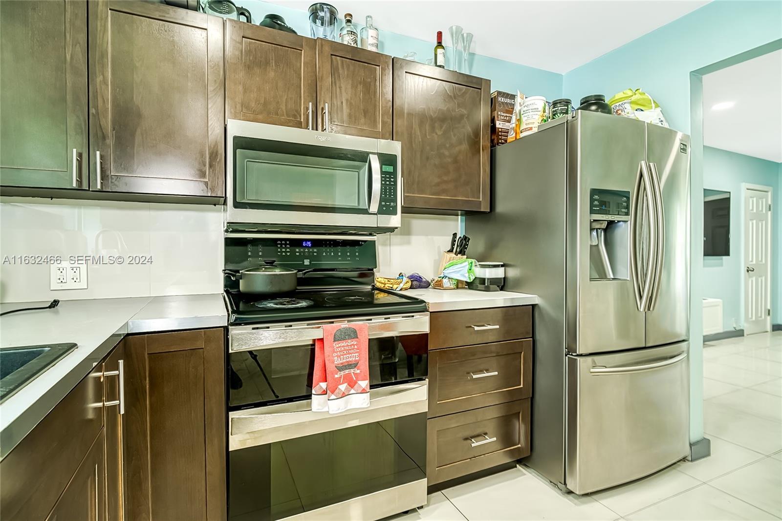 216 Southwest 6th Street Hallandale Beach, FL 33009 - Photo 5 of 70 a kitchen with stainless steel appliances granite countertop a refrigerator and a microwave