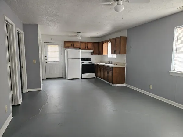 an empty room with a kitchen and a sink