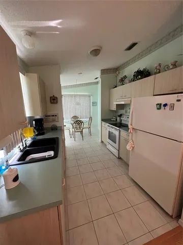 a kitchen with granite countertop a refrigerator and a stove top oven