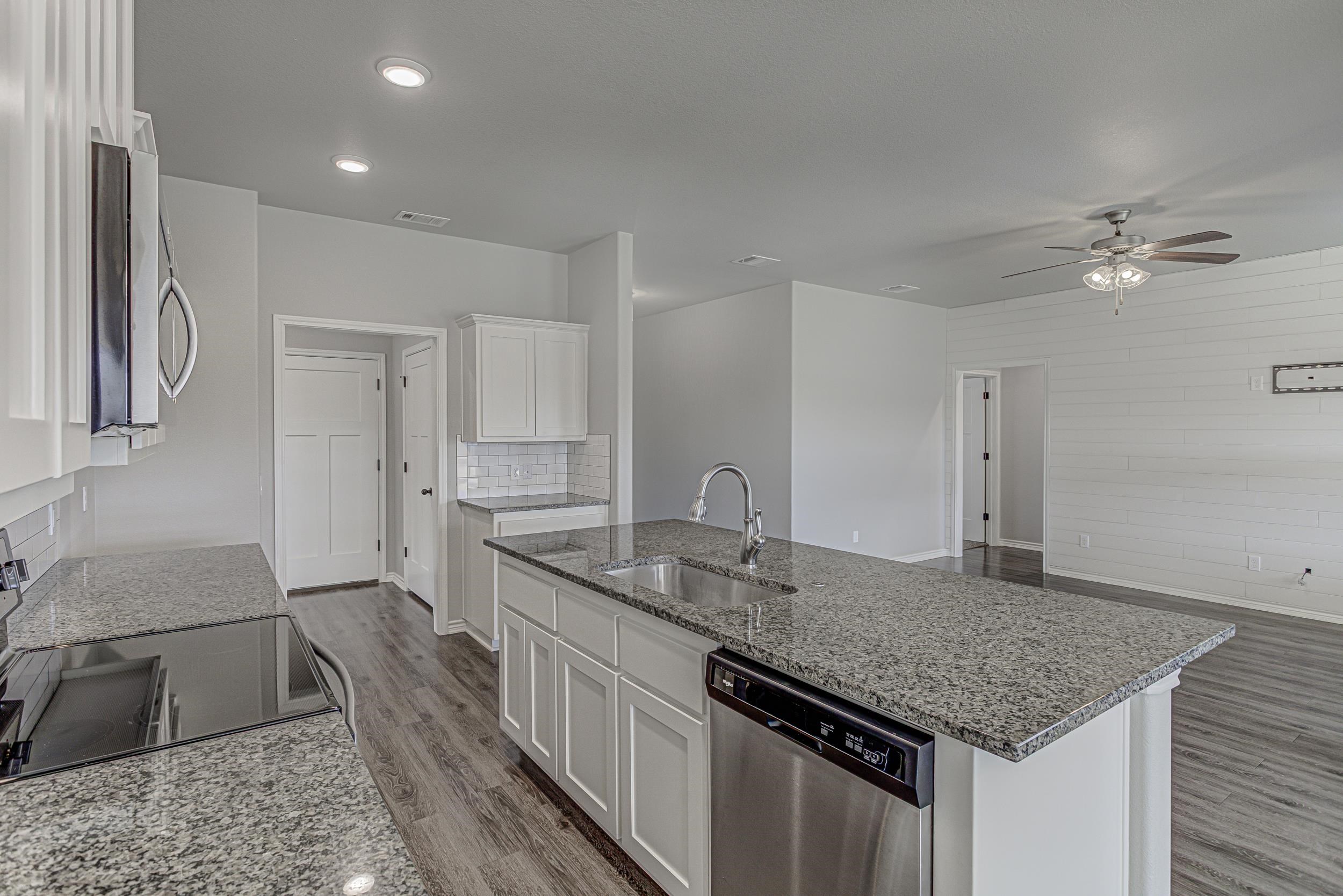 141 Rylee Road Burnet, TX 78611 - Photo 14 of 26 a kitchen with a sink dishwasher and a stove with wooden floor
