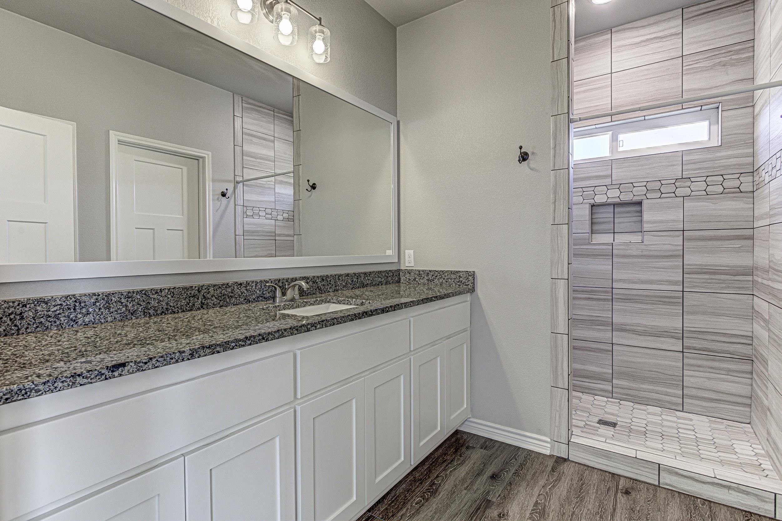 141 Rylee Road Burnet, TX 78611 - Photo 20 of 26 a bathroom with a granite countertop sink and a mirror