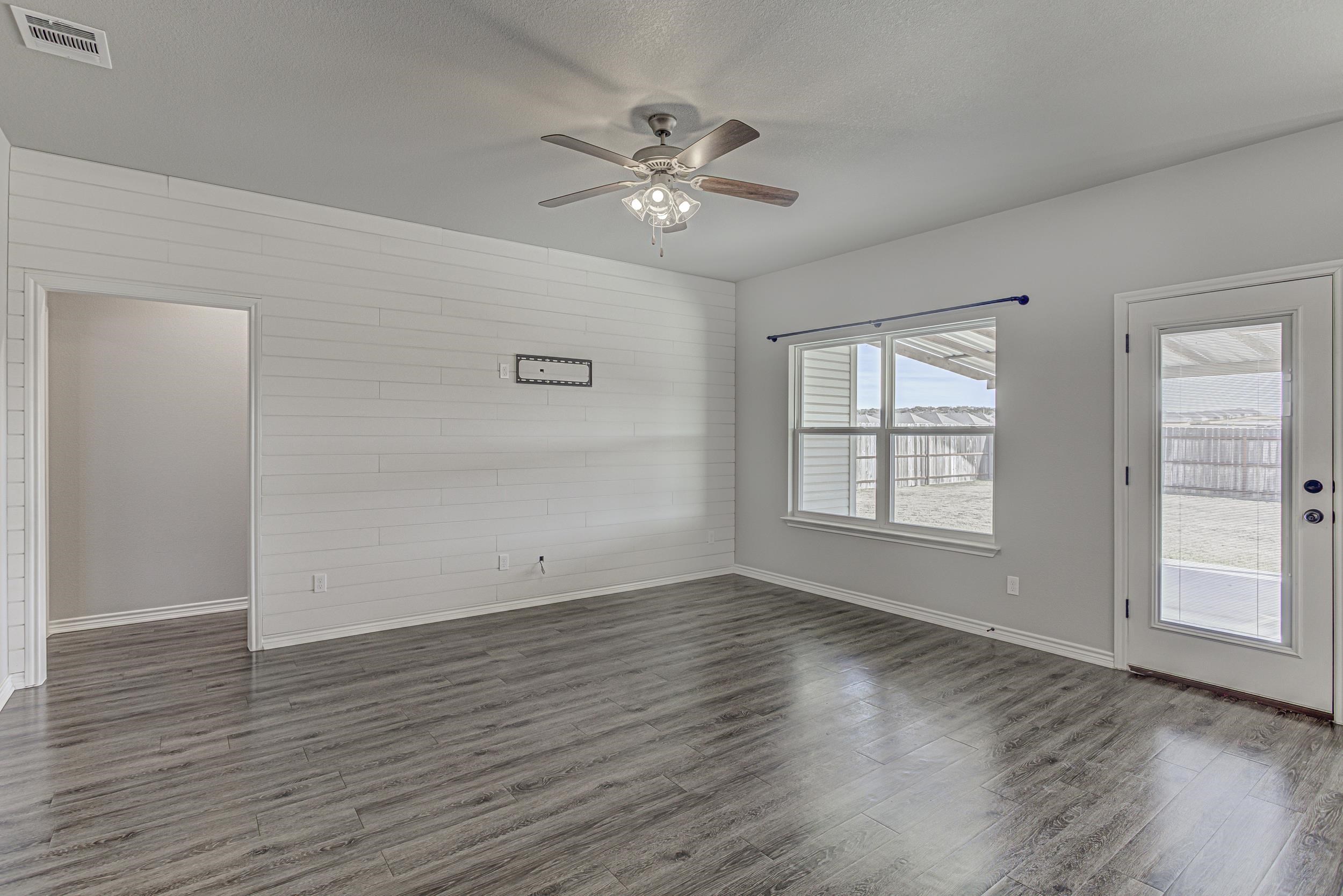 141 Rylee Road Burnet, TX 78611 - Photo 7 of 26 wooden floor in an empty room with a window