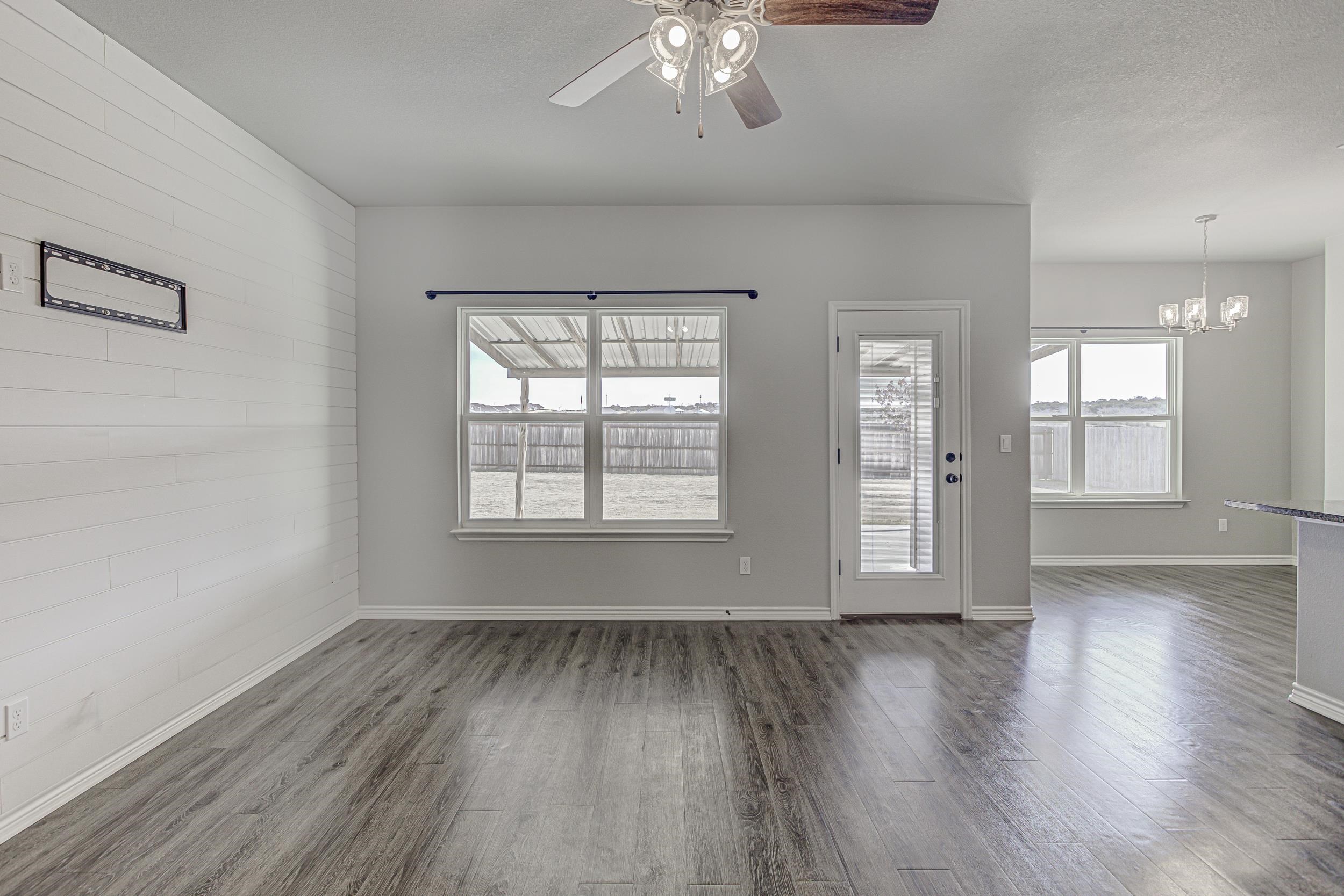 141 Rylee Road Burnet, TX 78611 - Photo 10 of 26 an empty room with wooden floor and windows