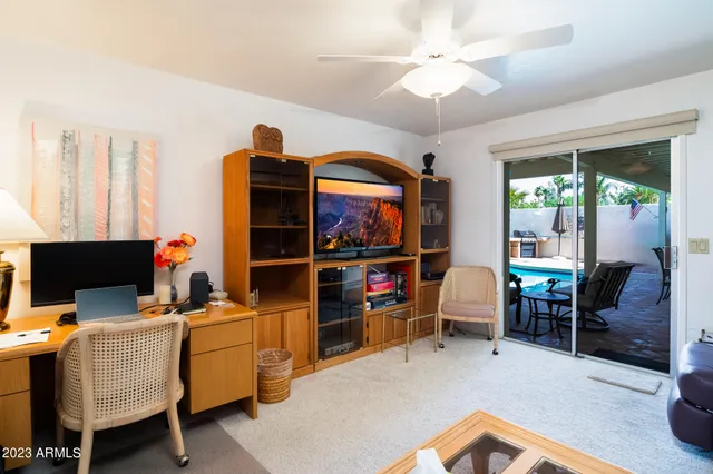 a view of a workspace with furniture and a window