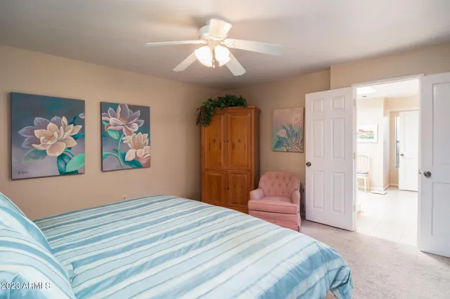 a bedroom with a bed dresser and a chandelier