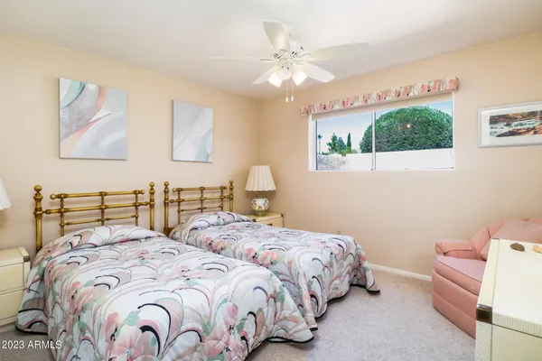 a bedroom with two beds and a chandelier