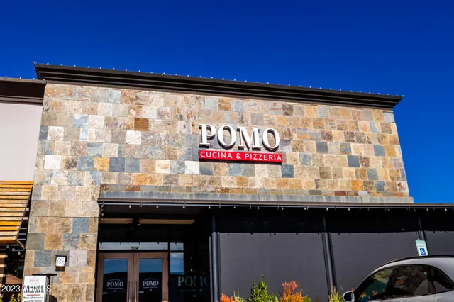 a front view of a building with streets and trees