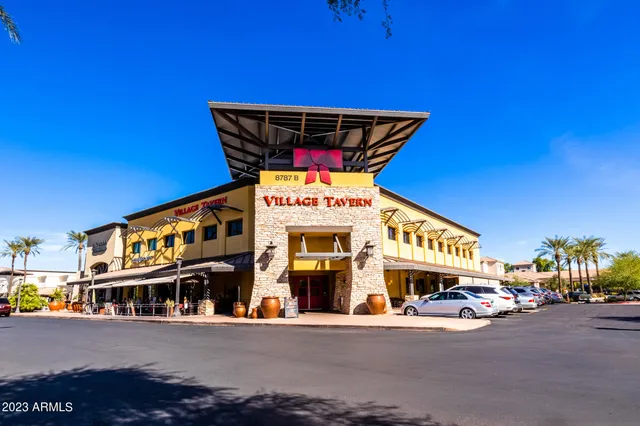 a front view of a multi story building with retail shops