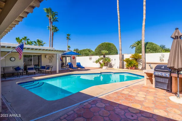 an outdoor space with swimming pool and furniture