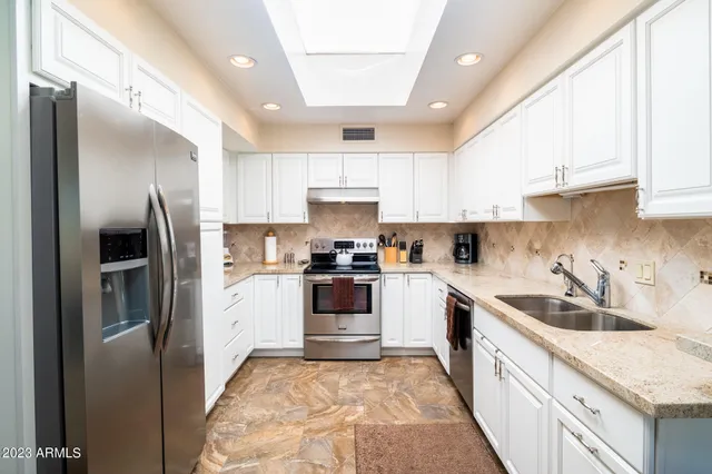 a kitchen with a sink a refrigerator and cabinets