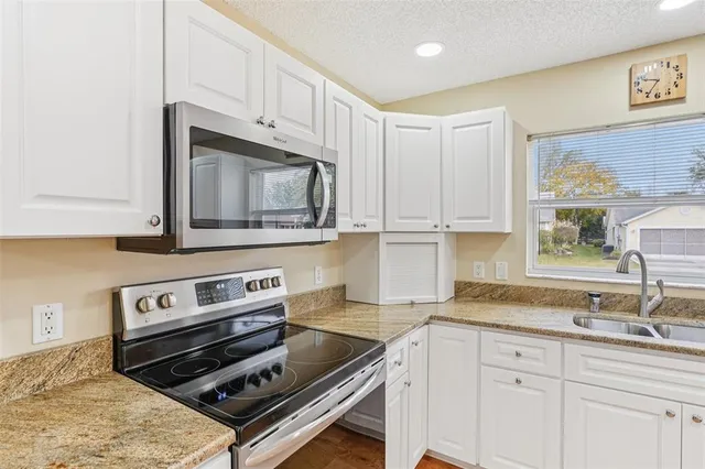 a kitchen with stainless steel appliances a refrigerator sink and cabinets