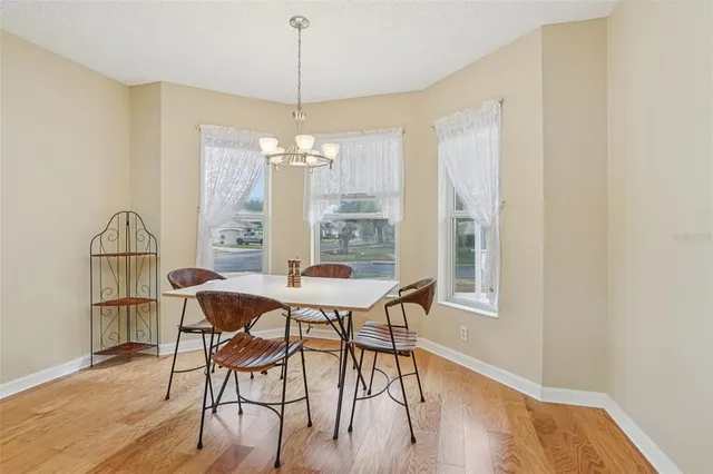 a dining room with furniture a chandelier and wooden floor