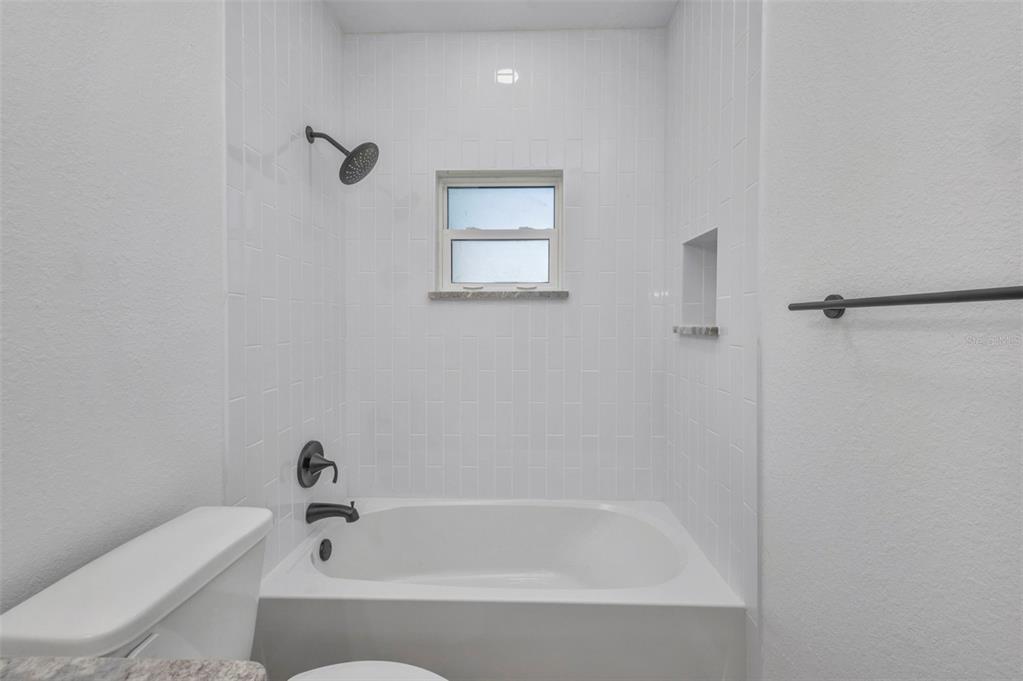 409 Carmalita Street, Unit 111 & 112 Punta Gorda, FL 33950 - Photo 15 of 75 a white bath tub sitting next to a toilet