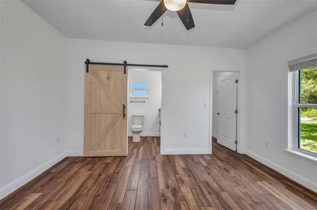 a bathroom with a granite countertop sink a toilet and shower