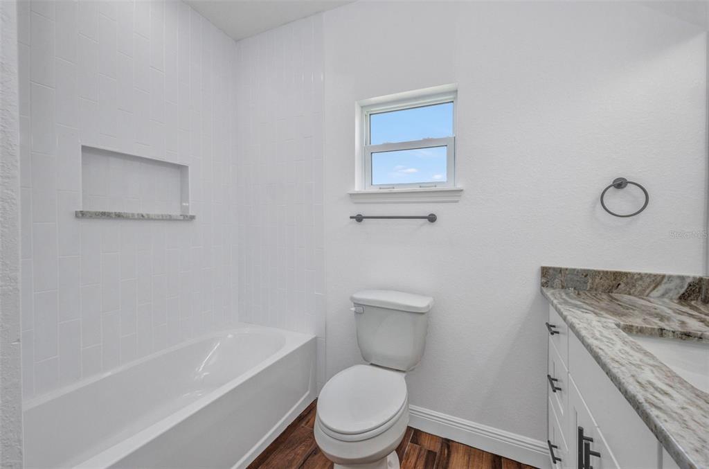 409 Carmalita Street, Unit 111 & 112 Punta Gorda, FL 33950 - Photo 28 of 75 a white toilet sitting next to a bath tub