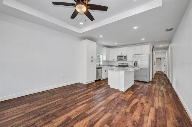 a view of empty room with wooden floor and window