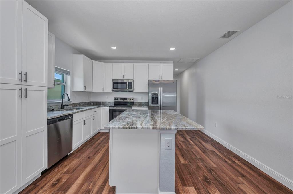 409 Carmalita Street, Unit 111 & 112 Punta Gorda, FL 33950 - Photo 35 of 75 a kitchen with kitchen island granite countertop stainless steel appliances cabinets a sink and a counter top space