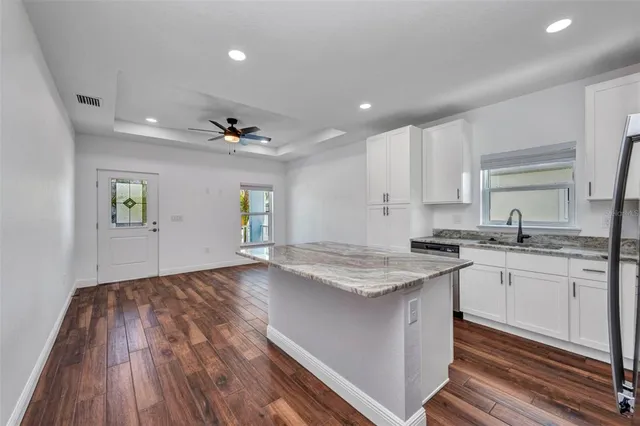 a bathroom with a granite countertop toilet a sink and a mirror
