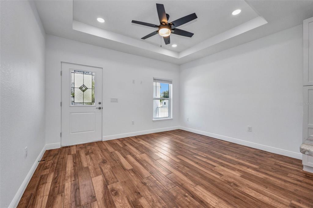 409 Carmalita Street, Unit 111 & 112 Punta Gorda, FL 33950 - Photo 38 of 75 an empty room with wooden floor ceiling fan and windows