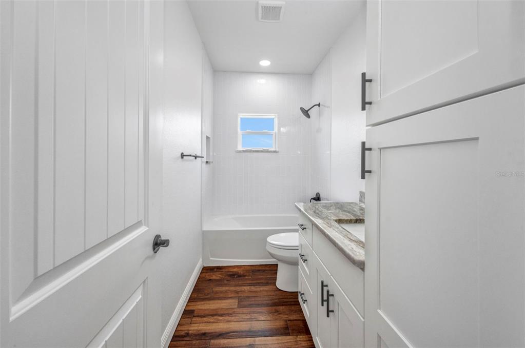 409 Carmalita Street, Unit 111 & 112 Punta Gorda, FL 33950 - Photo 40 of 75 a bathroom with a granite countertop sink a toilet and shower