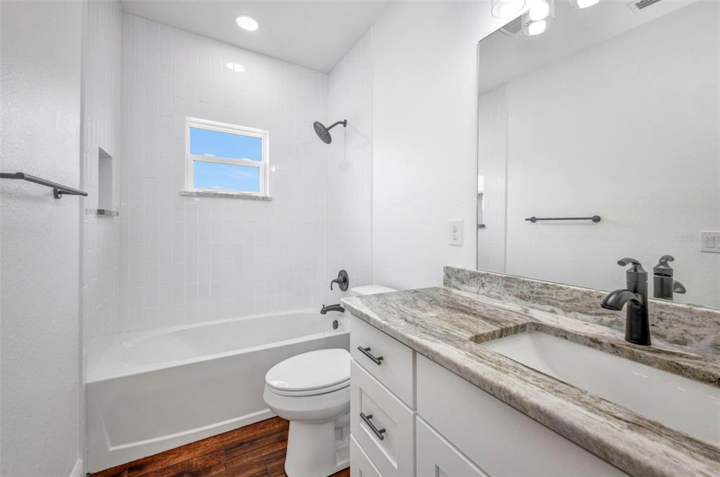 409 Carmalita Street, Unit 111 & 112 Punta Gorda, FL 33950 - Photo 41 of 75 a bathroom with a granite countertop sink a toilet and shower